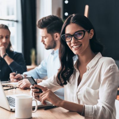Young modern colleagues in smart casual wear working while spending time in the office